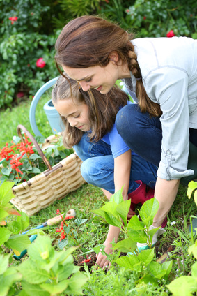 Little girl helping her mother to do gardening